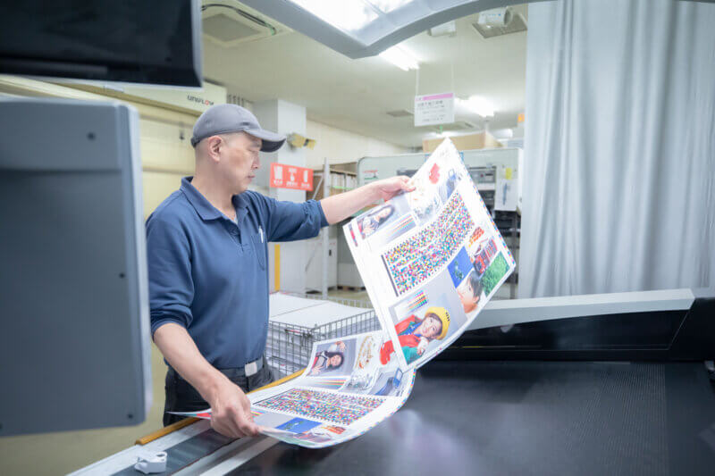 サンプルを見比べる印刷オペレーター