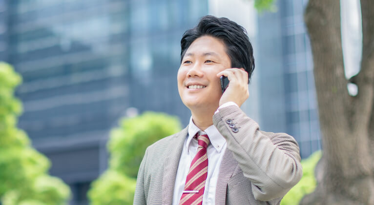 スマートフォンで電話をしている男性の画像
